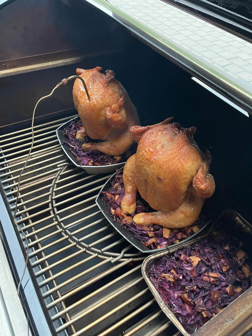 Foto z Wber grilovací akademie. Pohled na připravená kuřata na stojáncích Weber Delux na plynovém grilu.